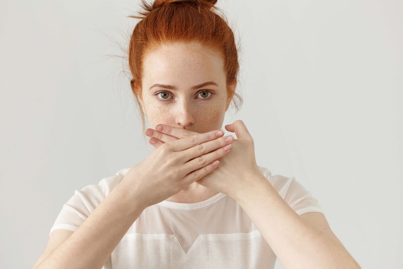 portrait-serious-young-ginger-european-woman-covering-mouth-with-both-hands-keeping-secret-freckled-redhead-female-blouse-doesn-t-want-spread-rumors-some-confidential-information copia